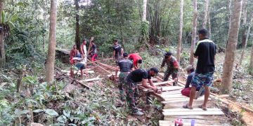 Prajurit Satgas Yonif 642 Bersama Warga Perbaiki Jembatan Yang Rusak Akibat Banjir
