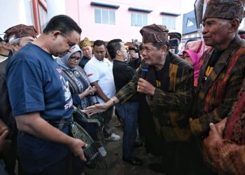 Kunjungi Siantar, Tokoh Masyarakat Ikatkan Kain Hiou Khas Simalungun Kepada Anies