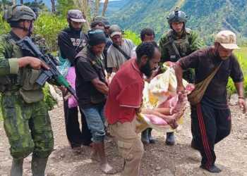 Anggota TNI dan warga mengevakuasi korban luka-luka akibat diserang TPNPB, di distrik Anggruk, kabupaten Yahukimo, Papua Pegunungan, Minggu (23/03/2025)