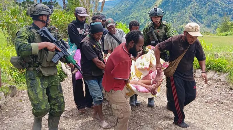 Anggota TNI dan warga mengevakuasi korban luka-luka akibat diserang TPNPB, di distrik Anggruk, kabupaten Yahukimo, Papua Pegunungan, Minggu (23/03/2025)